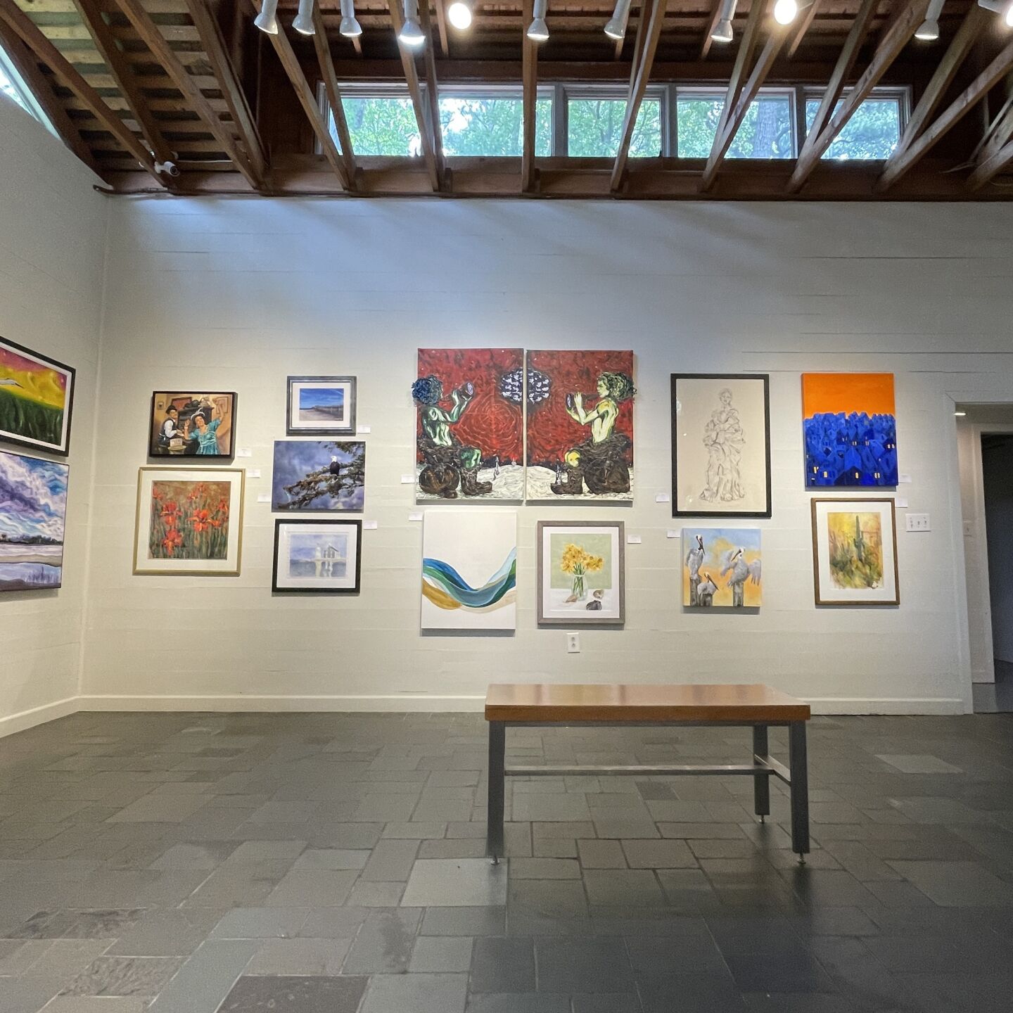 art gallery with white walls and a brown bench